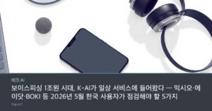 A smartphone lying face up on a bright desk beside a small microphone and a pair of headphones