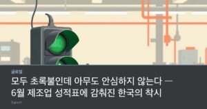 A large green traffic light beside a metal gear and a magnifying glass on a bright factory workbench