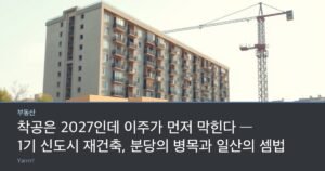 Stacked moving boxes and a rolled carpet in front of an old apartment block with a tower crane behind