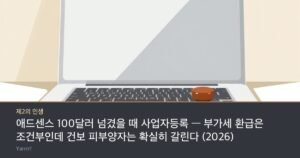 A closed silver laptop beside a short stack of coins and a red ink pad with a wooden personal seal, bright daylight desk